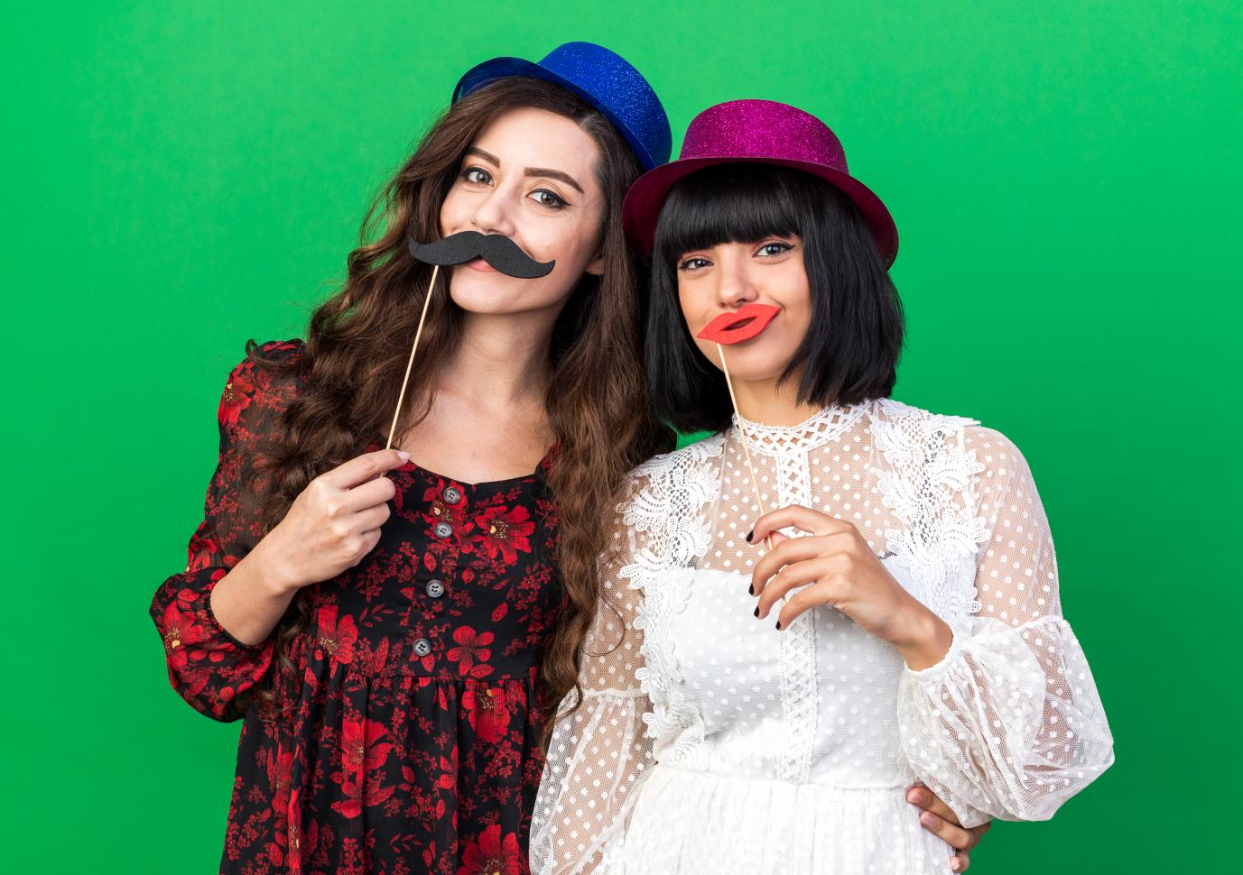Two Girls are posing front of Green Screen